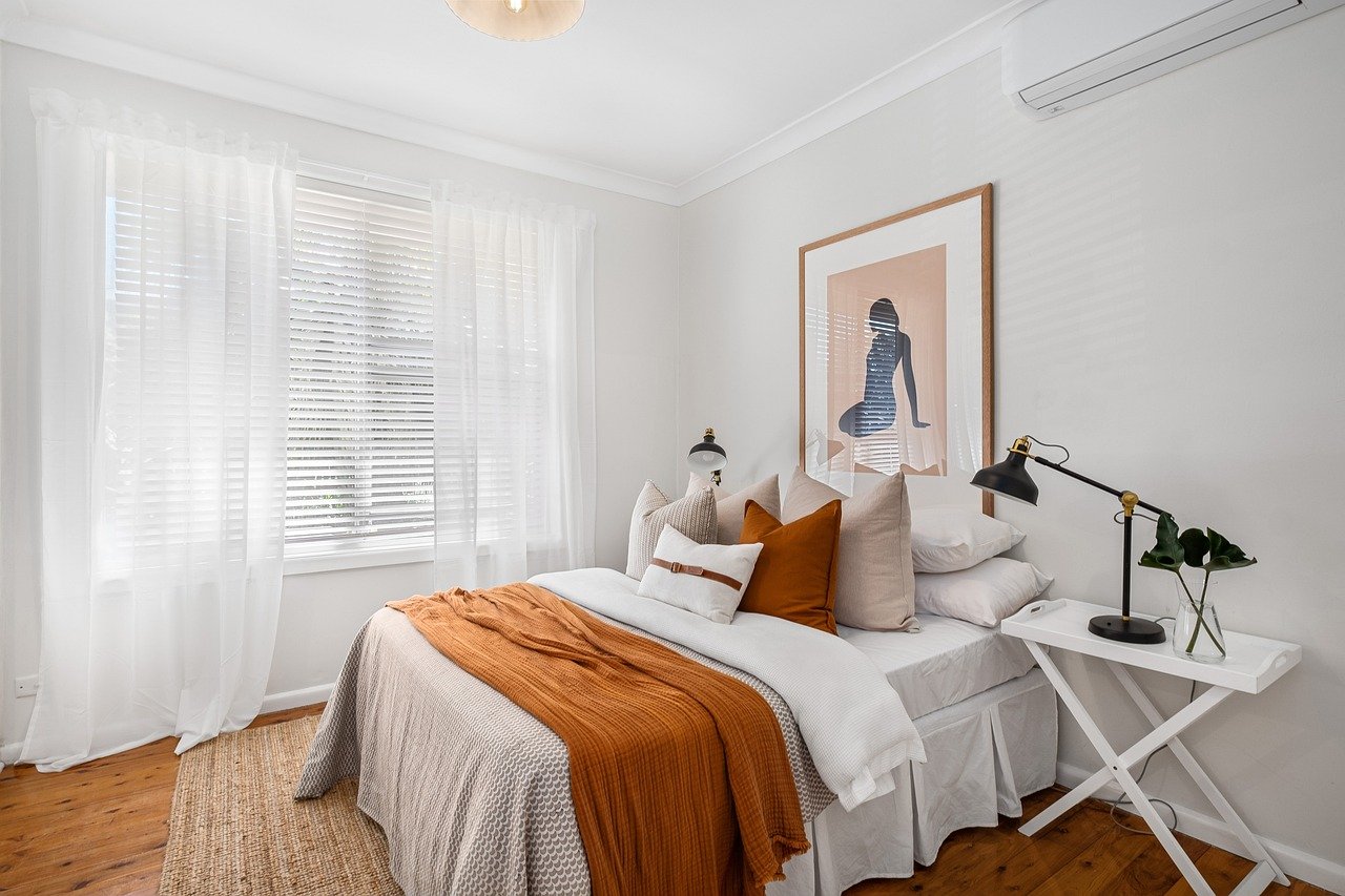 Diseño de dormitorio contemporáneo que combina texturas decorativas en tonos neutros y muebles flotantes.